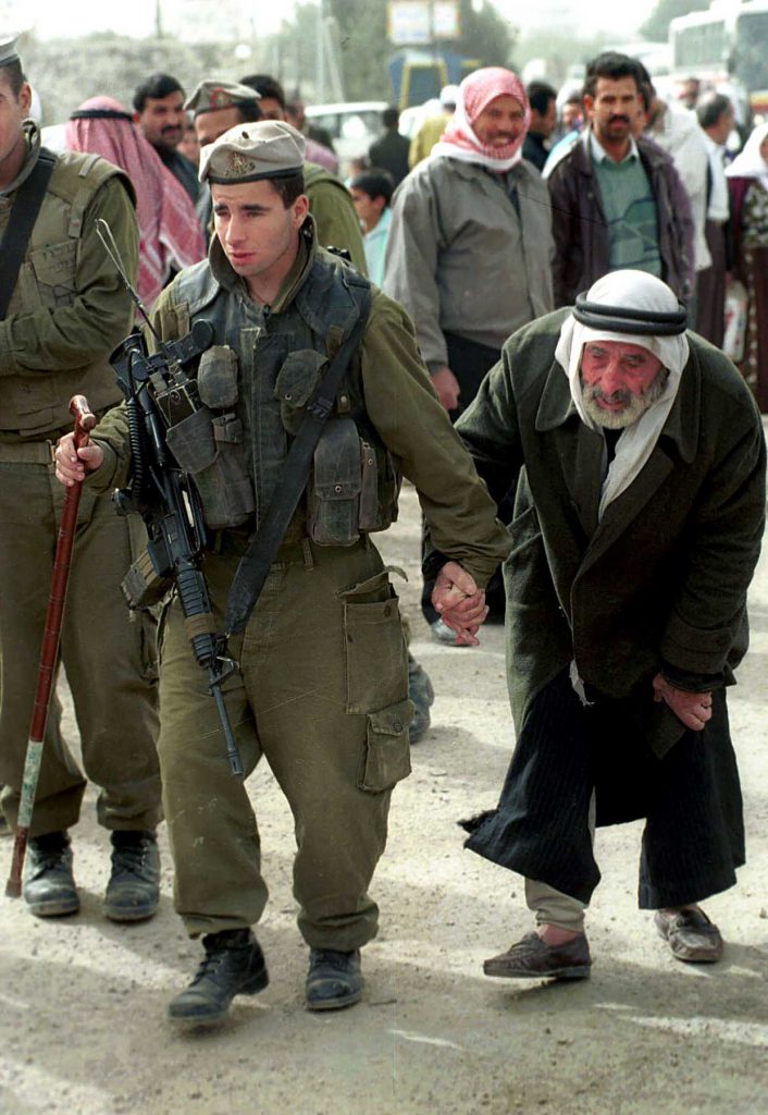 An Israeli soldier helps an elderly Palestinian man cross through the Bethlehem checkpoint on February 9, 1996. Photo by  Nati Shohat /Flash90. *** Local Caption *** ????? ????? ??? ??? ??? ??? ??? ???? ?????? ???? ???? ???????? ?????? ???? ????? ??????? ???????? ??????? ???????? ???????? ????????? ???????? ?????????